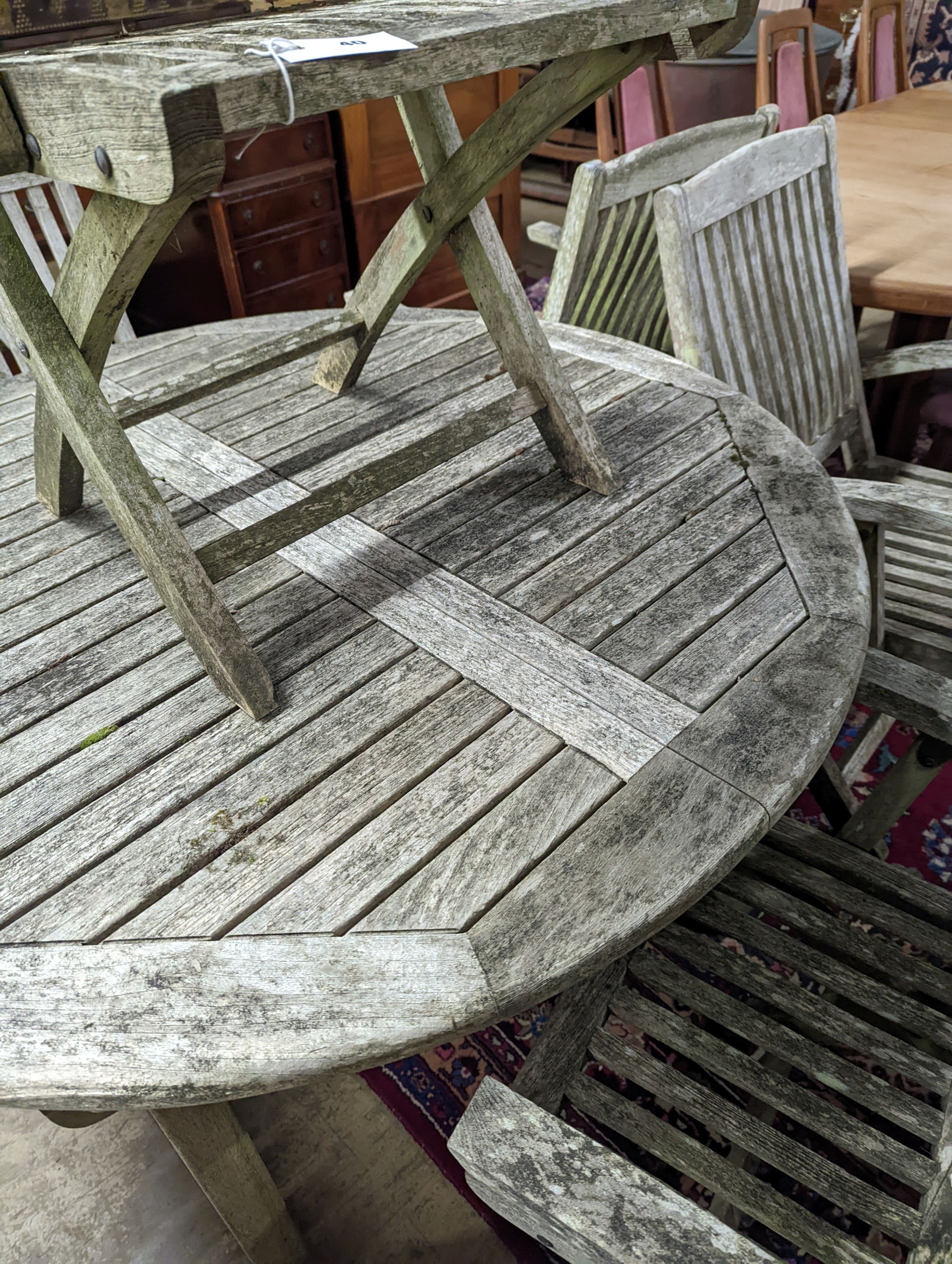 A weathered teak circular extending garden table, 120cm diameter, height 74cm together with five Lindsey teak folding garden elbow chairs